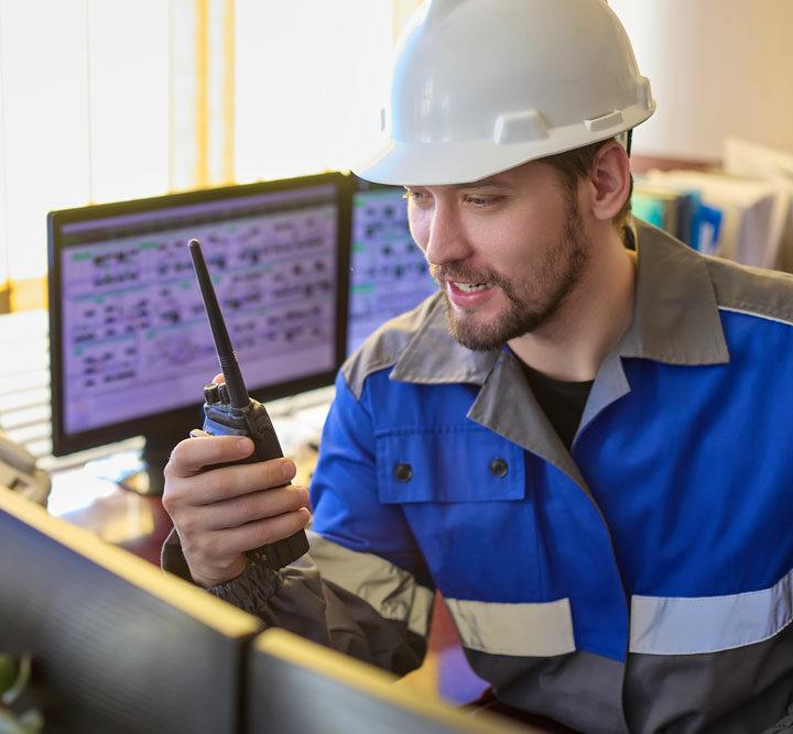 Construction worker with computer shown communicating to represent responsive resource management